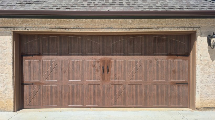 Two-car wood-look garage door with carriage hardware detail